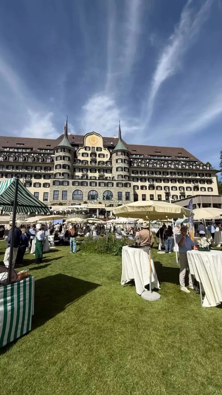 Il prato di un Grand Hotel di St. Moritz durante il Gourmet Festival, con ombrelloni e ospiti